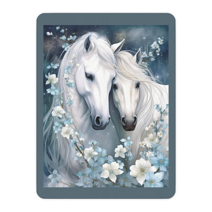Two white horses with flowing manes surrounded by flowers on a dark blue background